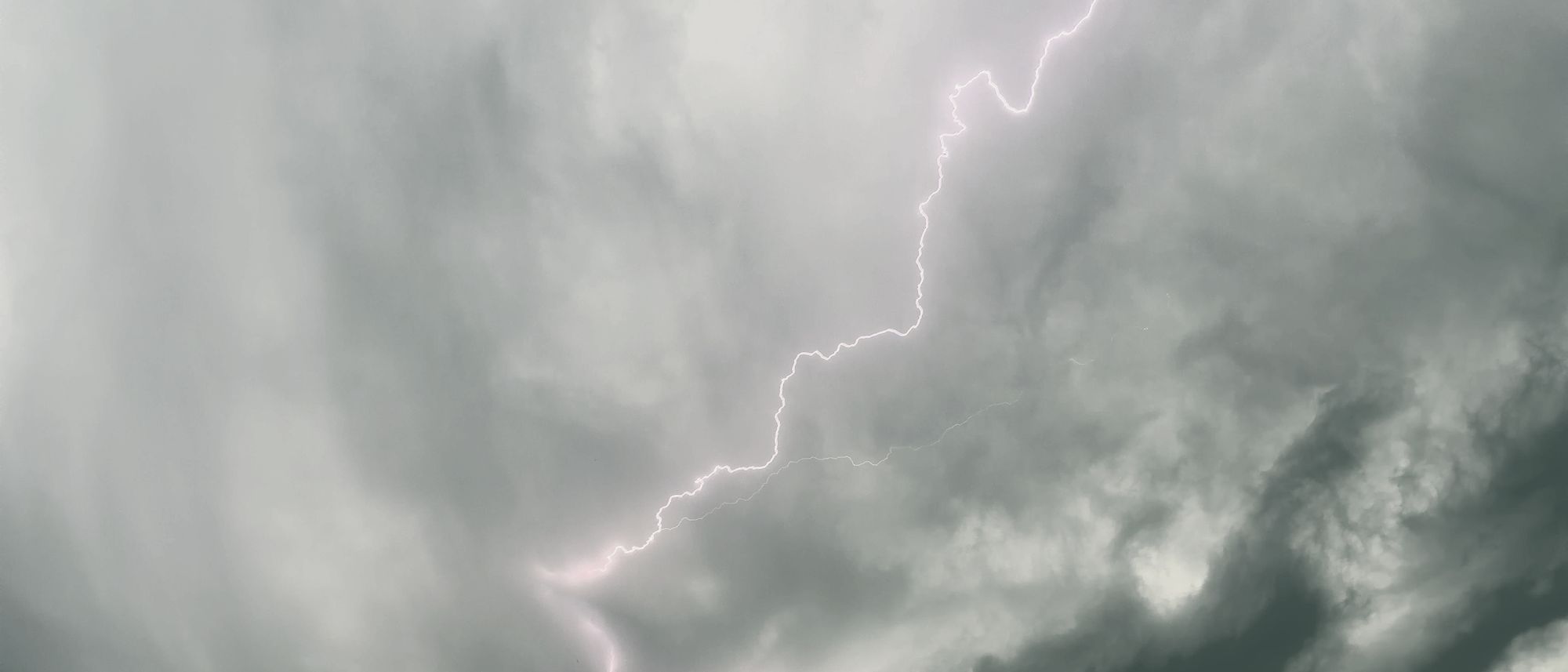 Ein Blitz in einer grauen Wolkenwand über Wien